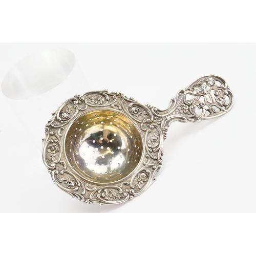 85 - A 830 marked silver cherub decorated tea strainer. Weight 51g.