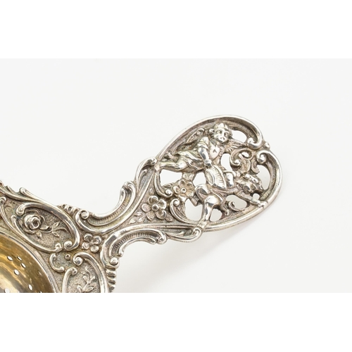 85 - A 830 marked silver cherub decorated tea strainer. Weight 51g.