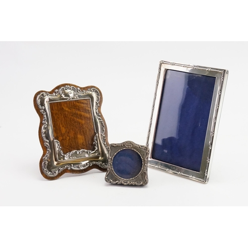 93 - A small silver photo frame, along with a larger silver frame, and a silver mounted card holder.