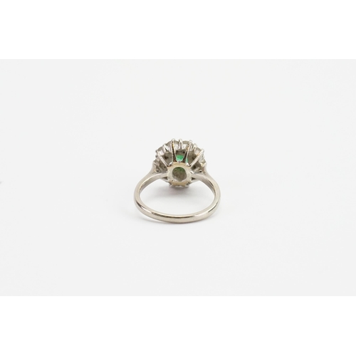 245 - A 18ct white gold diamond and emerald (6.8mm x 5.1mm) set ring. Set with 10 0.09ct diamonds. Size M.... 