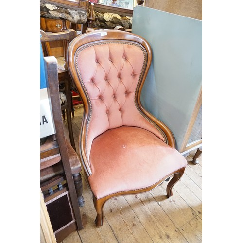 558 - A Victorian Design stained as Mahogany Button Back Arm Chair resting on carved feet.