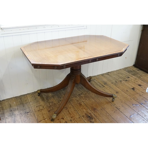 533 - A Regency designed Walnut banded Extending Dining Table resting on swept out brass covered feet & Ca... 