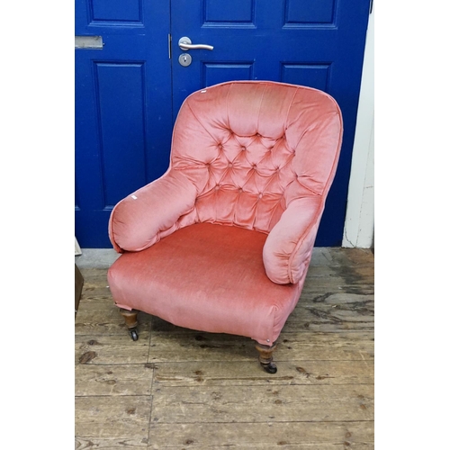 538 - A Victorian Button Backed Easy Chair in Pink Velour resting on turned legs.