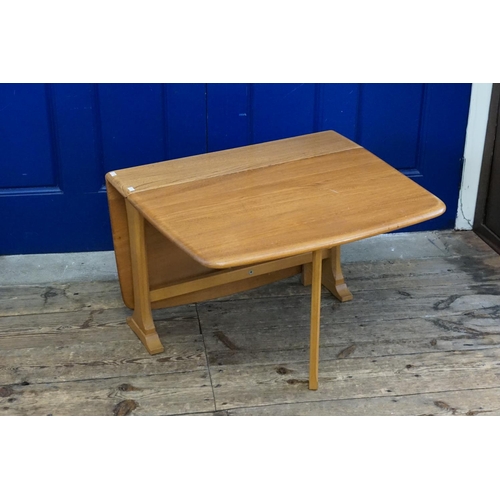 544 - An Ercol Elm drop flap coffee table resting on a shape support.