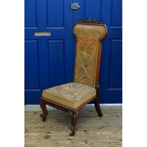 557 - A mid Victorian Mahogany framed Prie-dieu chair with original needlework covering and resting on car... 