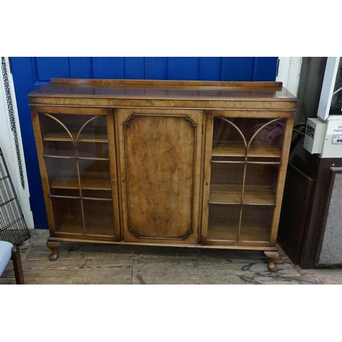 565 - A 1930s Walnut & Mahogany Bookcase with Astragal Glazed End Doors & a panelled centre door & resting... 