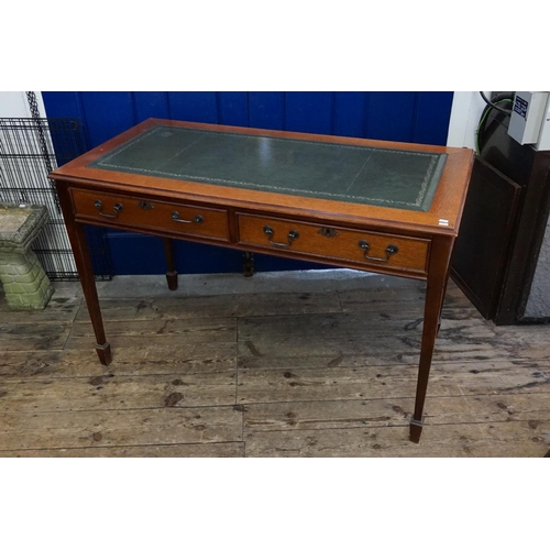 569 - An Oak Two Drawers Writing Table resting on spade feet. Measuring: 123cms across x 58cms deep x 76cm... 