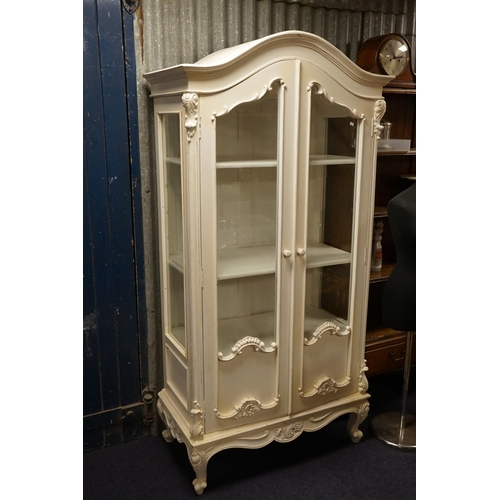 573 - A White Painted Glass Fronted & Side Panelled Display Cabinet with a domed top, Gadrooned decoration... 