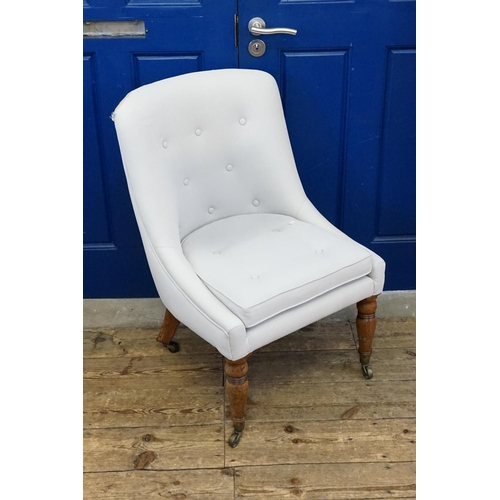 576 - A Victorian Button Backed Easy Chair resting on turned front legs with brass castors & shaped back. ... 