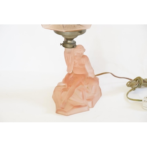 317 - A 1920s pink dressing table lamp with a young lady on a rock.