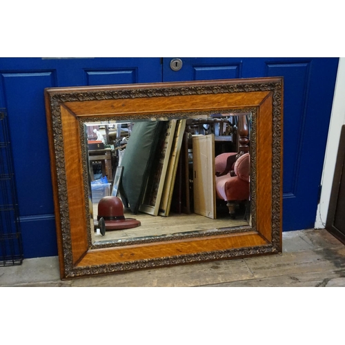 605 - A French Design Bevelled Glass Wall Mirror in an Oak Frame. Measuring: 107cms across x 84cms high.