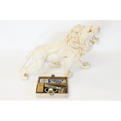 629 - A silver plated Wilkinson razor and an Italian pottery lion.