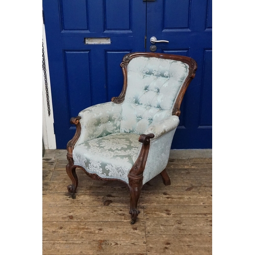 522 - A blue covered Victorian arm chair.