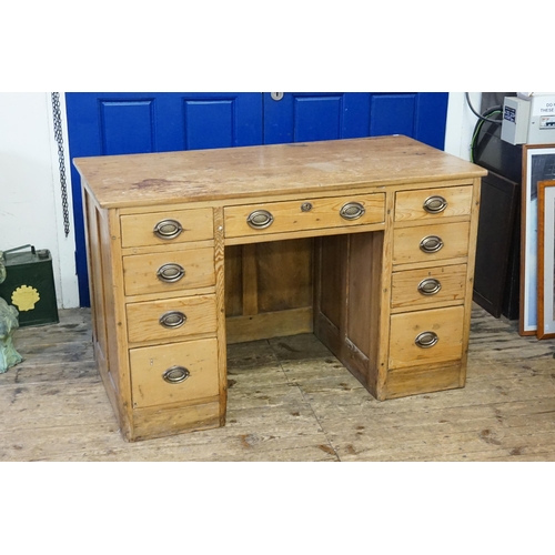 523 - An antique pine desk, fitted with 9 drawers. 127cm x 65cm x 80cm.