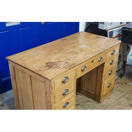 523 - An antique pine desk, fitted with 9 drawers. 127cm x 65cm x 80cm.