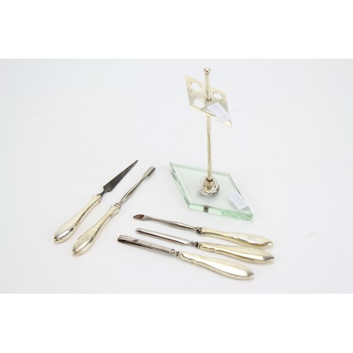 85 - A Silver Art Deco manicure set mounted on a glass stand.