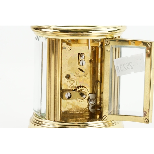 405 - A Modern Oval Brass Cased Carriage Clock with an enamelled face, Black Chaptering & Carrying Handle.... 