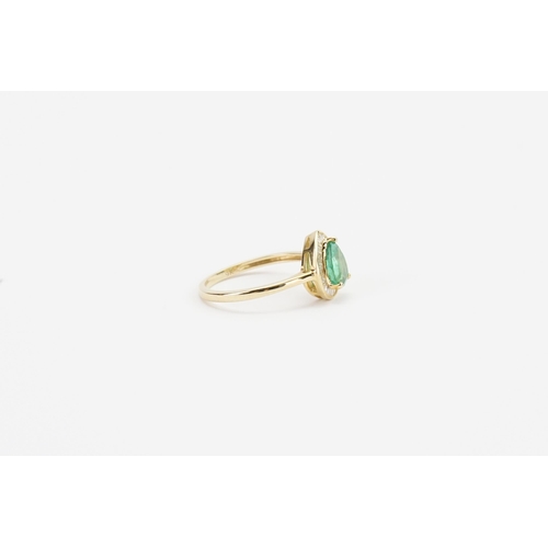 282 - A 9ct pear cut emerald ring (approx 1ct) surrounded by baguette diamonds. Weight 2.4g.