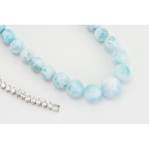 280 - A blue stone silver set bead necklace, along with a similar silver ring, and a paste tennis bracelet... 