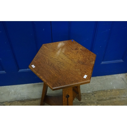 664 - A Liberty's design Oak Hexagonal Topped Table with pierced legs. Measuring: 70cms high.