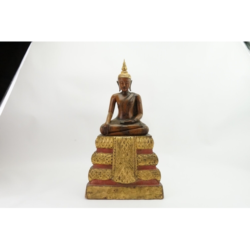 416 - An Asian Carved Wooden Seated Buddha in Wood with Gilt Highlights seated in the Lotus Position on a ... 