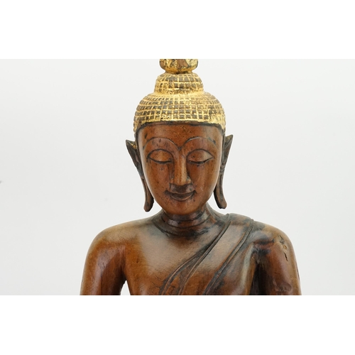 416 - An Asian Carved Wooden Seated Buddha in Wood with Gilt Highlights seated in the Lotus Position on a ... 