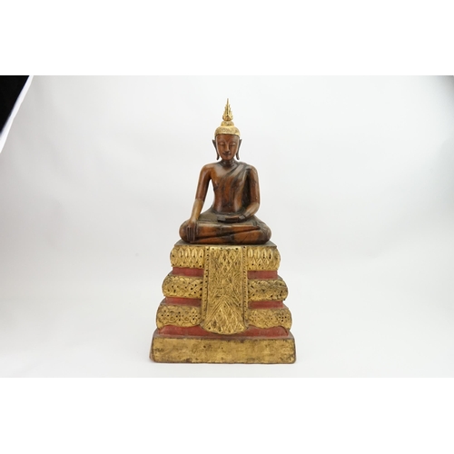 416 - An Asian Carved Wooden Seated Buddha in Wood with Gilt Highlights seated in the Lotus Position on a ... 