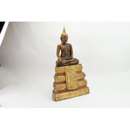 416 - An Asian Carved Wooden Seated Buddha in Wood with Gilt Highlights seated in the Lotus Position on a ... 