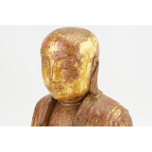 418 - A Carved Red Lacquered & Gilded highlights Study of a seated monk, his hands open palmed & Cross sea... 