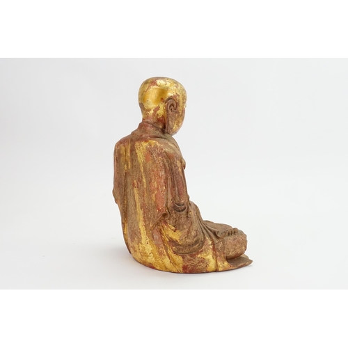 418 - A Carved Red Lacquered & Gilded highlights Study of a seated monk, his hands open palmed & Cross sea... 