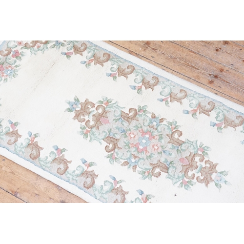 731 - A Beige Ground Floral edged Runner with a stitched edge. Measuring: 325cms long x 82cms across.