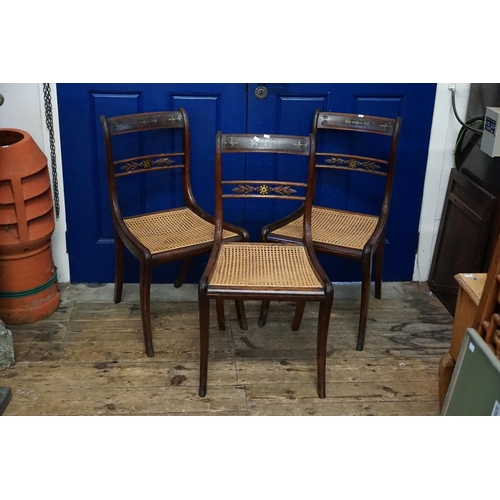 714 - A Set of Three Regency Brass inlaid Bergere seated Dining Chairs resting on Sabre Legs.