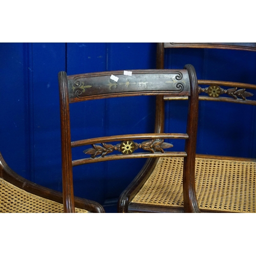 714 - A Set of Three Regency Brass inlaid Bergere seated Dining Chairs resting on Sabre Legs.