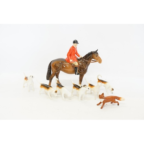 1055 - A Beswick Hunting Group comprising of a Huntsman on Brown Horse, 6 Hounds & a Fox.