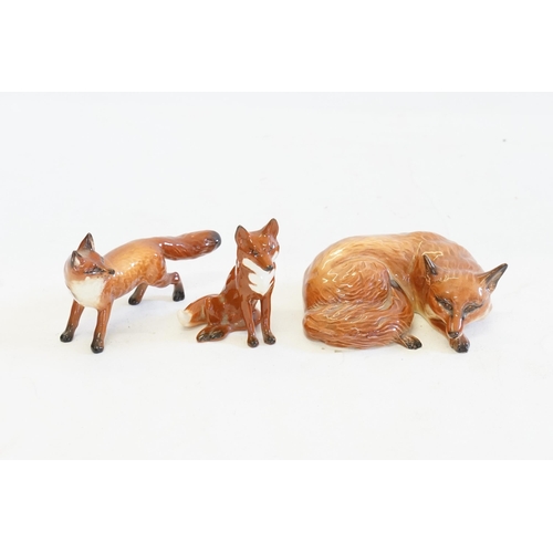 1080 - Three various Beswick Studies of Foxes seated, Recumbent & On Alert.