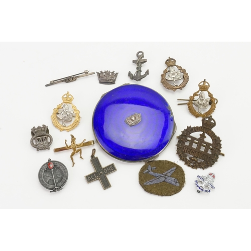 744 - A collection of regimental badges and brooches, to include the Royal Navy crown set in enamelled com... 