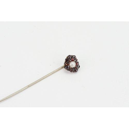 156 - A garnet and pearl set stick pin.