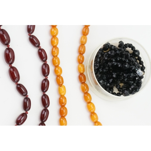 310 - An amber style necklace, red bead necklace and a quantity of glass beads.