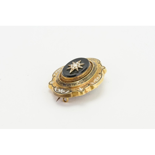 229 - A 9ct gold onyx inlaid mourning brooch, with pearl design. Size 4.6cm x 3.7cm.