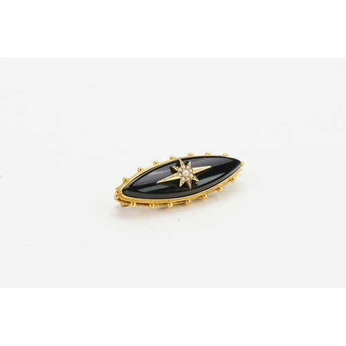 230 - A 18ct gold onyx set mourning brooch, with pearl star decoration. Measures 4cm x 1.3cm. Weight 6.9g.