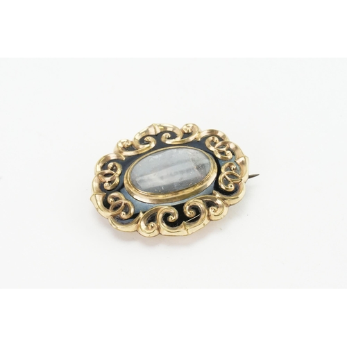 234 - A gold coloured onyx set mourning brooch. Weight 17.9g.