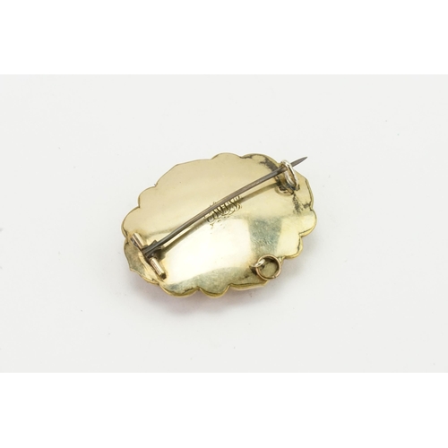 234 - A gold coloured onyx set mourning brooch. Weight 17.9g.