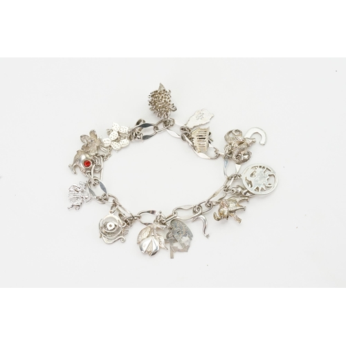 224 - A silver charm bracelet, hung with silver charms to include hedgehog, elephant, fish etc. Weight 43g... 