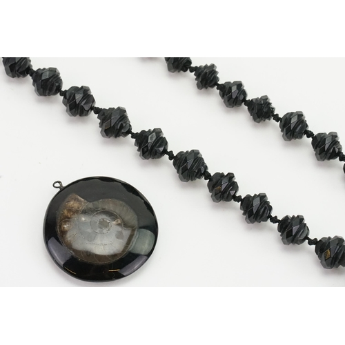 209 - A French Jet bead necklace, along with a fossil decorated pendant.