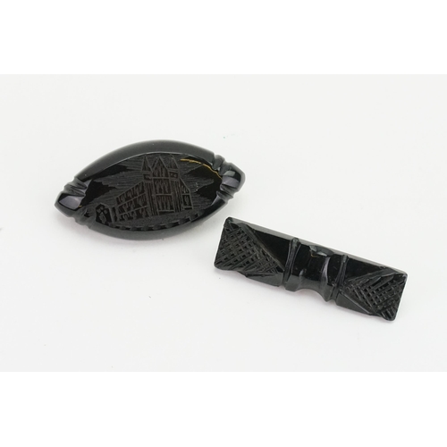 203 - A pair of carved Jet brooches, one carved with a church. Possibly Whitby. Weight 10g.