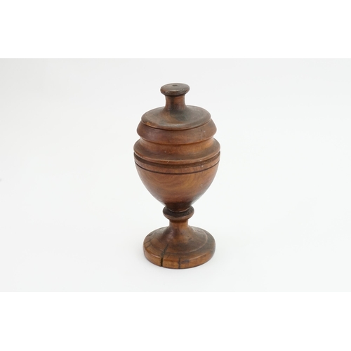 609 - A late 19th Century Turned Olive Wood Vase & Cover resting on a pedestal base. Measuring: 25cms High... 