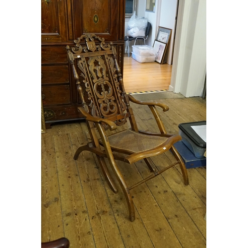 438 - A Victorian Walnut Framed Pierced & Carved Back Fold-Up Coaching Chair with a Cane Seat.