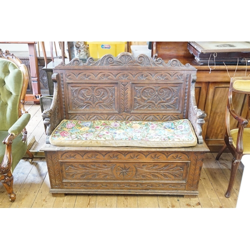 430 - A Late 19th Century Carved Oak Monk's Bench with a pierced Scroll Top & Lions End Mounts. Measuring:... 