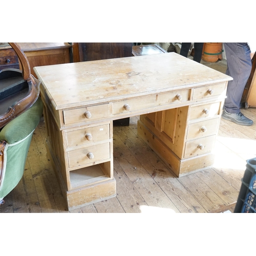 446 - A Reproduction Pine Pedestal Desk. Measuring: 110cms across x 74cms deep x 77cms high.