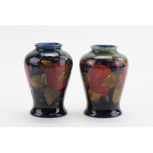 664 - A Pair of Moorcroft Pomegranate Bulbous Vases decorated in Puce, Blue & Red. Standing: 9cms high.